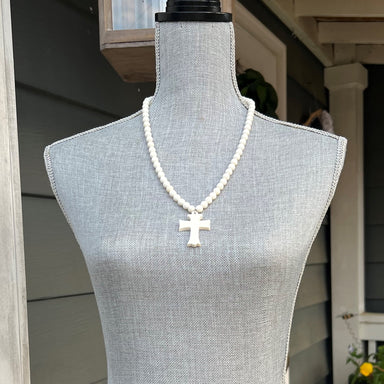 This luxurious necklace is handcrafted with round camel bone beads and detailed with an intricately hand-carved cross. The 26" length and sophisticated materials make this necklace an exquisite addition to any wardrobe.