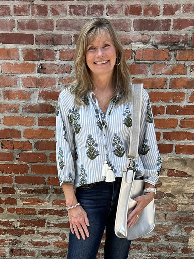 Start your fall season off with our Striped Flower Print Top! This peasant-style top features a light blue and white striped background adorned with a dark blue floral design. The elastic and tie neckline allows for a customizable fit, while the full sleeves with banded cuffs add a touch of elegance.&nbsp;

Material: 100% Cotton

Care Instructions: Gentle cool hand wash, dry flat