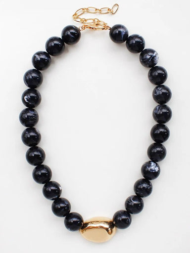 Timeless elegance meets natural beauty in this Black Natural Stone Beaded Necklace. Strung with smooth 8mm black stone beads, it features a striking gold-centered charm that adds refined sophistication to any look. The earthy appeal of natural stone pairs perfectly with the warm gleam of gold, creating a piece that works beautifully layered or worn alone. Effortlessly versatile, it transitions from casual daytime wear to evening sophistication with ease.

Length: 16-18"