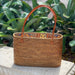Handcrafted ata vine and rattan tote bag featuring sturdy leather handles and a charming patterned lining. Compact yet durable, this small tote is perfect for everyday essentials. The natural woven construction offers both style and functionality, making it an ideal accessory for work, shopping, or travel. A versatile piece that combines artisanal craftsmanship with practical design.

Dimensions: 11 × 8 × 4&nbsp;in

Material: Ata Vine and Rattan, Leather Strap, Batik Print Lining (pattern varies)