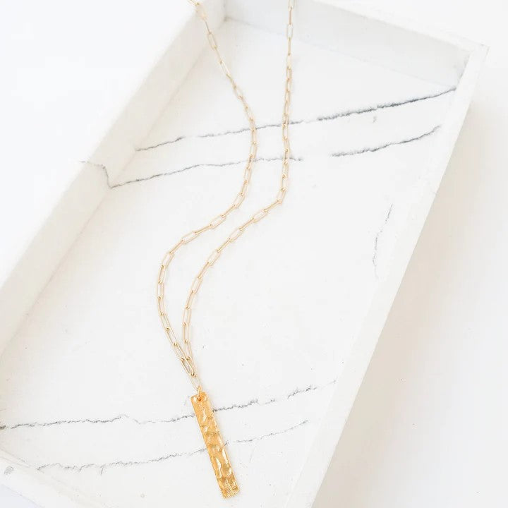 Add a touch of elegance and versatility to your jewelry collection with our Paperclip Chain Necklace w/ Bar Drop. This delicate chain necklace features a hammered bar drop, making it the perfect accessory for any occasion - from casual to dressy.  Solid Brass 19” Long 