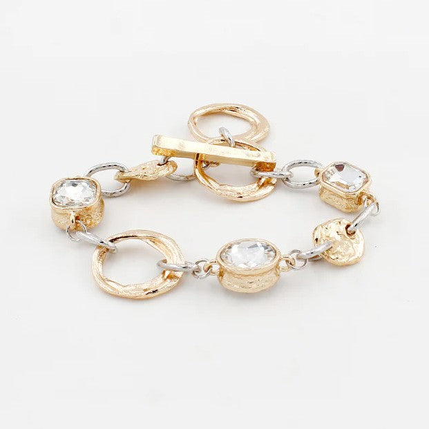 This Gold &amp; Silver Textured Chain Bracelet combines unique gold elements with elegant silver chains, secured by a stylish T-bar closure. Its versatile design lets you effortlessly transition from casual days to dressed-up evenings, adding a refined touch to any look.&nbsp;