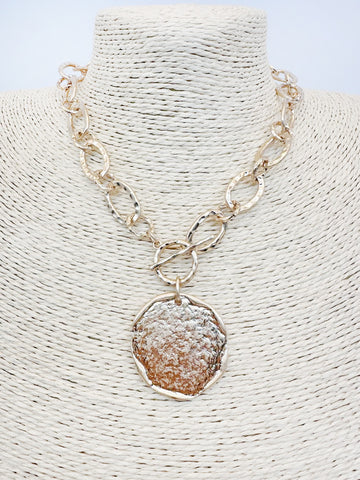 This open chain necklace features a striking hammered gold coin pendant that adds a distinctive touch to any outfit. The convenient T-bar front closure makes it easy to wear, whether you're dressing up for a special occasion or keeping it casual. Its unique design ensures you stand out with effortless style.

Length: 16-18"