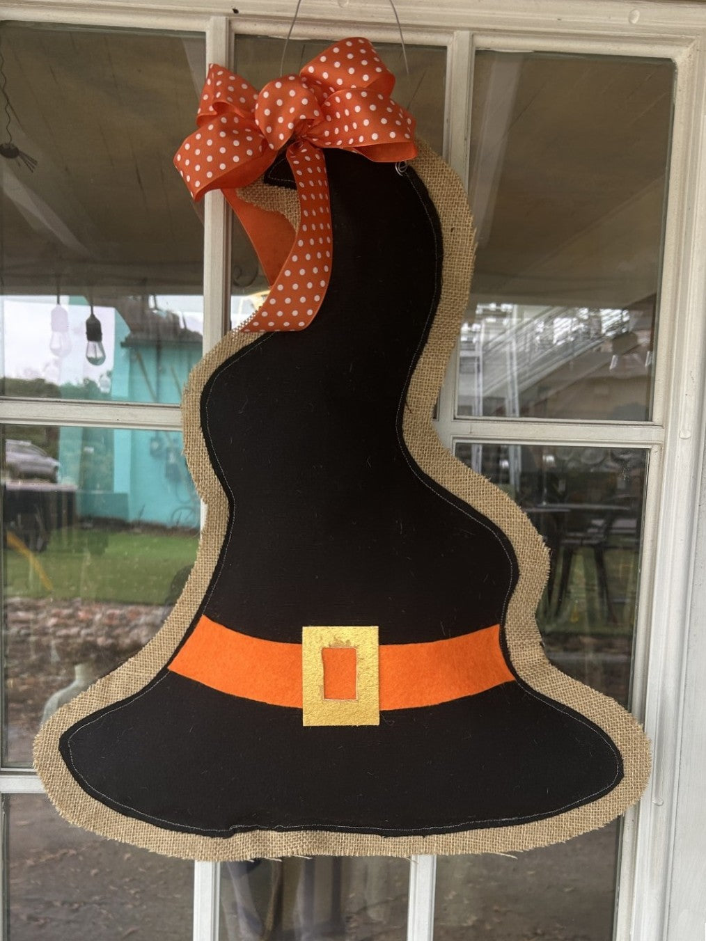 This&nbsp;Witches Hat door hanger is an easy way to decorate for Halloween! We love it's super cute and not too spooky! Hang on your front door or in your house as a statement in your Halloween décor.&nbsp;

It is not weather proof, so it needs to be hung in a covered area.&nbsp;

Our door hangers are made right here in Georgia by local textile artist, Allison Wright and provides an oh, so easy way to decorate! Allison uses a combination of assorted burlaps, fabrics, ribbons and paints to produce her unique