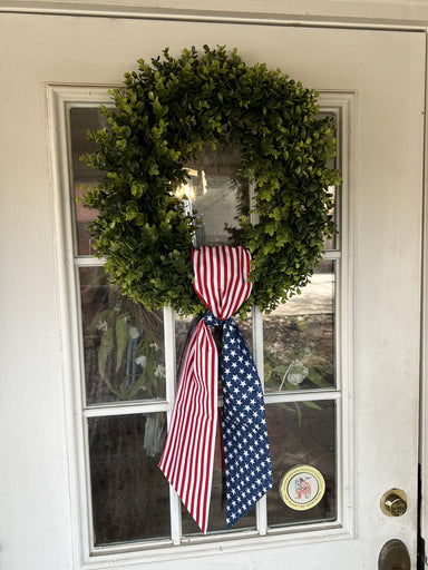 The addition of this beautiful round 20" boxwood wreath is the perfect accent piece for your home. Use this wreath all year long for some added greenery to your home. Covered in lush vibrant preserved boxwood leaves, on a thick vine base, enjoy this wreath season after season.  Sashes are not included but you can add our beautiful wreath sashes to your boxwood wreath to celebrate game day or different seasons of the year!