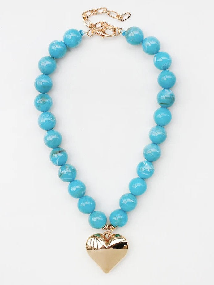 Warm turquoise beads create understated elegance, while a delicate heart charm adds a touch of sentiment. The 18 mm beads catch light beautifully, making this necklace ideal for layering or solo wear. Effortlessly versatile—perfect for everyday moments and special occasions alike. A timeless piece that complements any style.