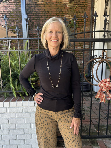 You will love this sleek black turtleneck with unique seam detailing at the neckline and wrists. Lightweight fabric makes it perfect for layering or wearing solo. Versatile enough to dress up or down—pairs effortlessly with jeans, skirts, trousers, or under blazers. A wardrobe essential that works for casual days and polished occasions alike.

Barbara is wearing a size Small.

Material: 66% Polyester / 29% Rayon / 5% Spandex

Care Instructions: Gentle wash cold, hang to dry