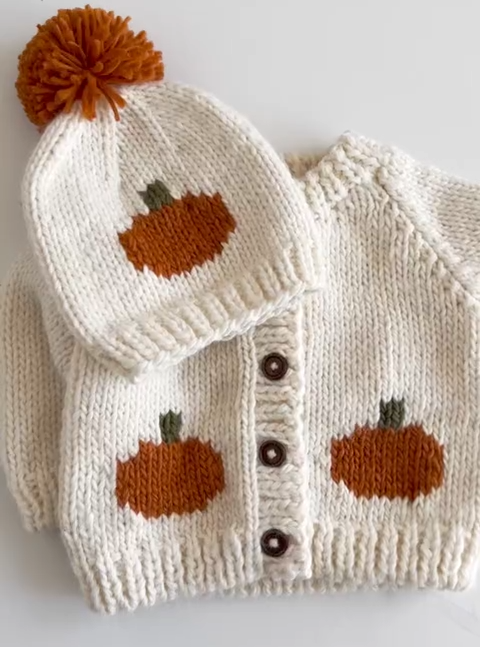 Knitted baby hat and cardigan with pumpkin pattern.