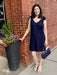 This adorable navy sleeveless dress features charming tie shoulder straps and playful contrasting ric rac trim along the neck and arms. Its versatile design easily transitions from day to night—simply switch up your shoes to suit the occasion. Perfect for adding a cute, stylish touch to any wardrobe.

Tara is wearing a size small. She added our lovely First Love Slip On High Heel, and our Ahdorned Small Flap Bag with Chain in navy.

Material: 30% Linen / 70% Rayon; Lining: 100% Polyester

Care Instructions: