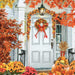Scene of a white front door featuring a wreath and garland made of fall leaves in yellows, oranges and browns. Pumpkins and mums are decoratively placed on the porch. 