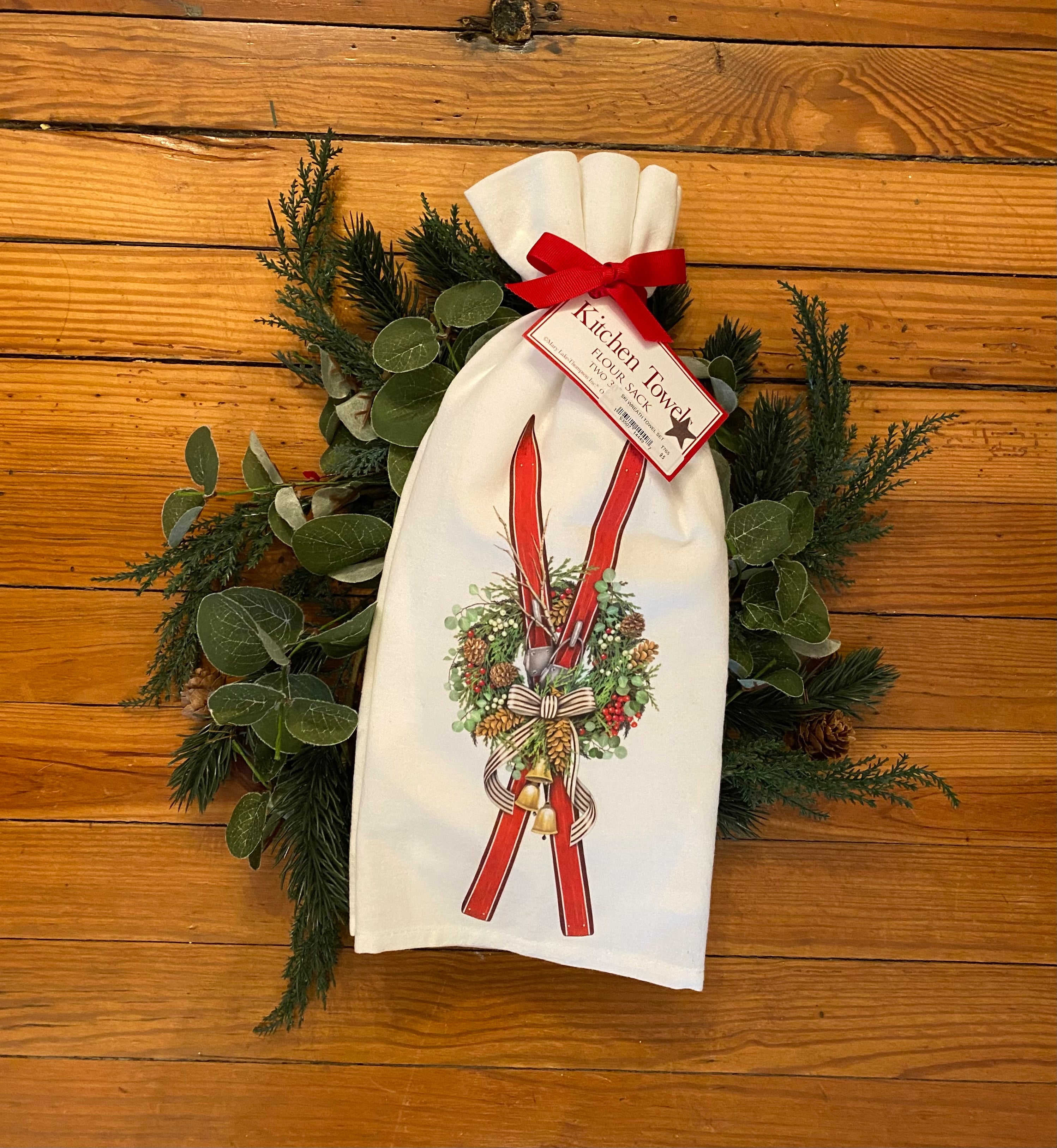 A lovely pair of seasonal flour sack towels. The design is a pair of red skis intermixed in a pinecone wreath. A festive way to dress up your home!  Two hand folded flour sack towels tied with a matching bow and hang tag 100% cotton, 30"x30"