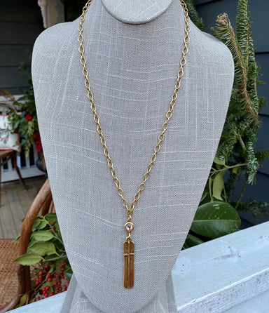 The is a lovely long gold necklace with a cross and crystal! The cross pendant is long and has a raised but hammered look. For a little shine, the cross drop is topped with a round crystal. It's a beautiful combination you will love!