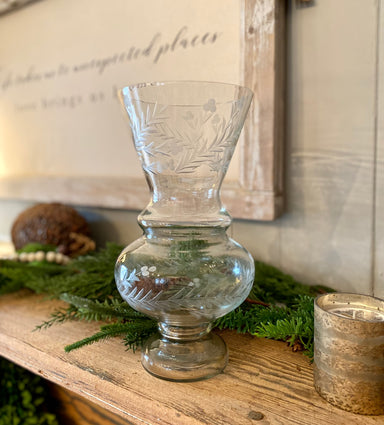 You will love this beautifully etched glass vase. This vase has a wide mouth and afooted base. It is delicately etched with a leaf and flower design. It is beautiful as is or filled with your favorite blossoms.  Approximate dimensions:  Small: 12" H x 6" W Medium: 15.5" H x 7.5" W