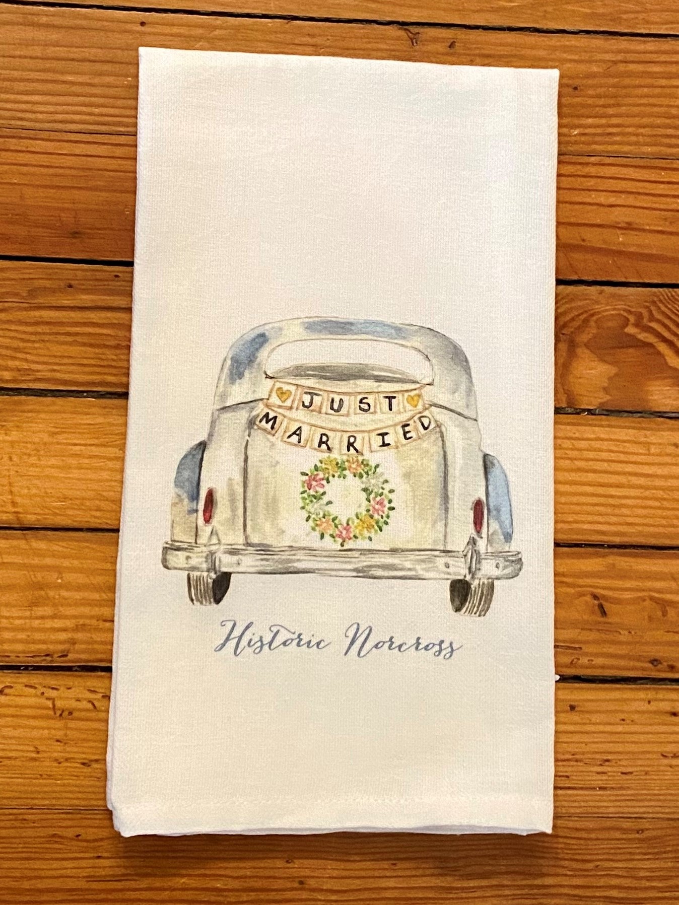 This is the sweetest gift for all of those you love who are getting married/married and are tied to Historic Norcross! It's a graphic of an old timey car with "Just Married" on the back. It's the perfect sentiment for a newly married couple.  Details:   ​100% Cotton Dimensions 20x25 inch
