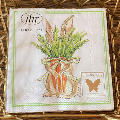 Precious spring or Easter themed cocktail napkins with a brown bunny holding a long bunch of carrots tied with a polka dot ribbon. The carrot greens are covering his face but his ears are standing up above them. Has a green border. 