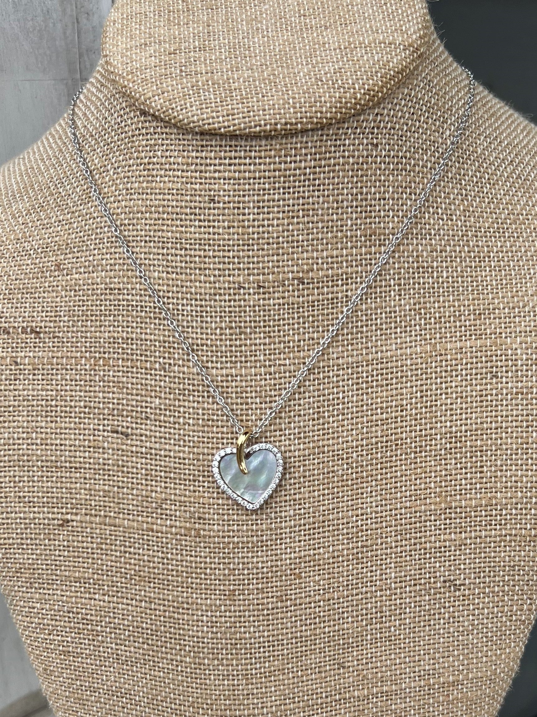 Such a beautiful, dainty necklace, approximately 16-18" in length. The front is a solid silver heart, outlined in rhinestones. The back is outlined in silver with several small hearts in the middle - you can wear it either way! Great for Valentines!