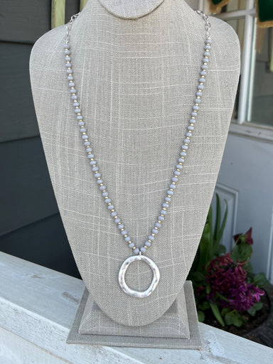This Gray Crystal & Silver Long Necklace with Hammered Circle Drop features a unique combination of stunning and eye-catching design elements. The necklace is 31-34" in length and features intricate details such as a silver chain and a gray crystal chain with a hammered circle drop. With its chic design and intricate decorative accents, this accessory is sure to add that final touch of elegance to any ensemble!