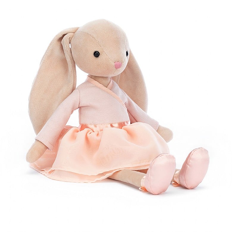 Lila Ballerina Bunny is the perfect addition to any nursery or bedroom. Crafted with a peachy jersey crossover wrap and double-layered tutu, Lila looks the part with her long ears flying out behind her, and her satin pointe shoes to complete the look. Measuring 13"H x 2"W, Lila Ballerina Bunny is sure to bring joy to any room.  Care: Hand wash only; do not tumble dry, dry clean or iron. Not recommended to clean in a washing machine.
