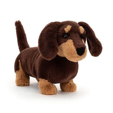 Otto Sausage Dog is the perfect companion - a playful pup crafted with dark chocolate fur, caramel patches, and golden eyebrows. His cute ears and perky tail will always be by your side. Otto is sure to bring joy and companionship.  Care: Hand wash only; do not tumble dry, dry clean or iron. Not recommended to clean in a washing machine.