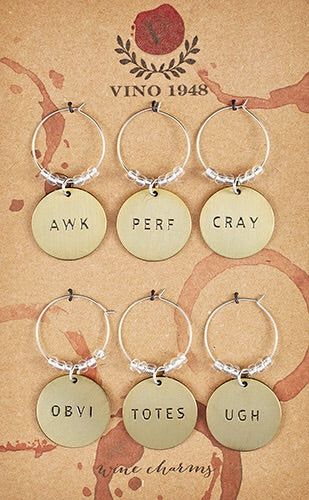 Brushed gold wine charm discs read AWK, PERF, CRAY, OBVI, TOTES, & UGH