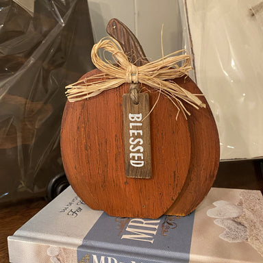 Rustic finished, orange wooden 2 dimensional pumpkin with brown stem, raffia bow and tag says Blessed