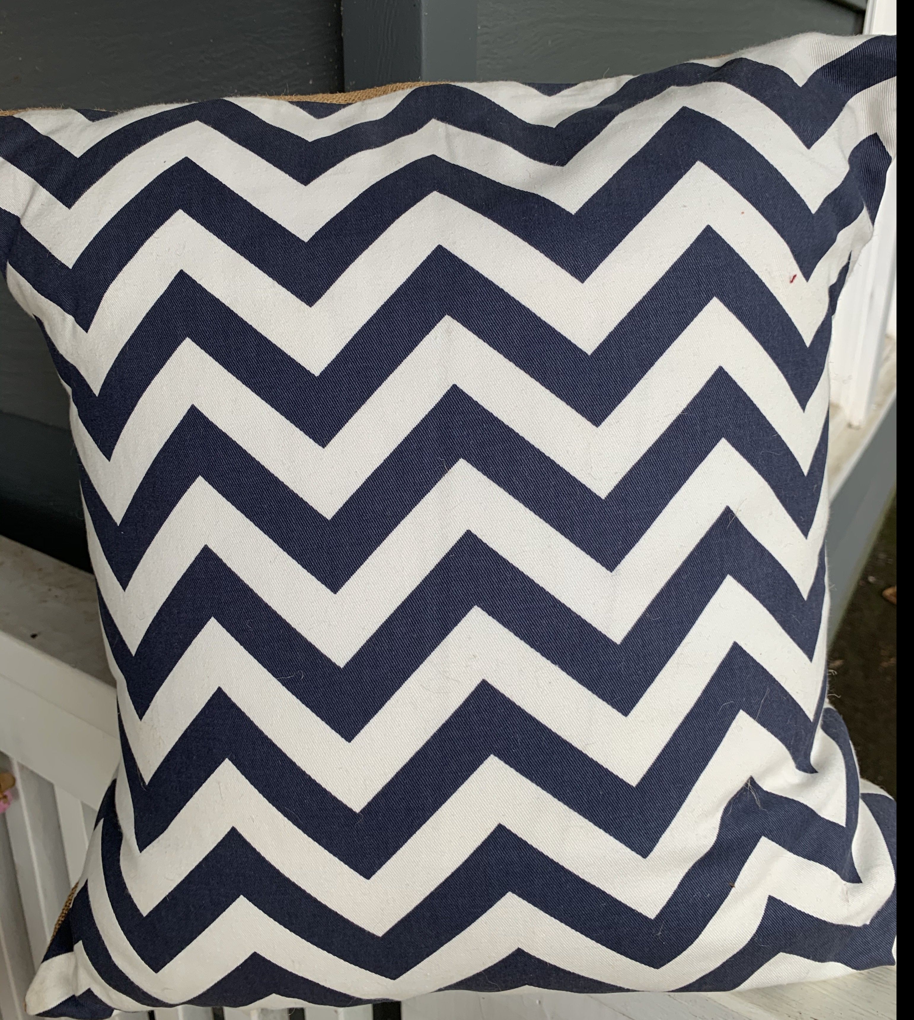 Navy & White Chevron print on the front and burlap on the pack. Pillow is stuffed with feathers.